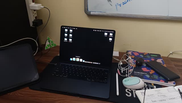 Person coding at a laptop with community workspace in background